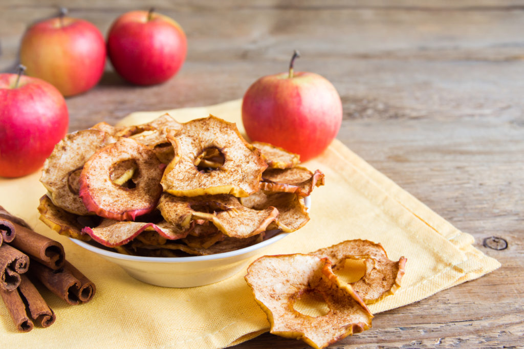 Organic apple cinnamon chips in bowl - healthy vegan vegetarian fruit snack or ingredient for cooking
